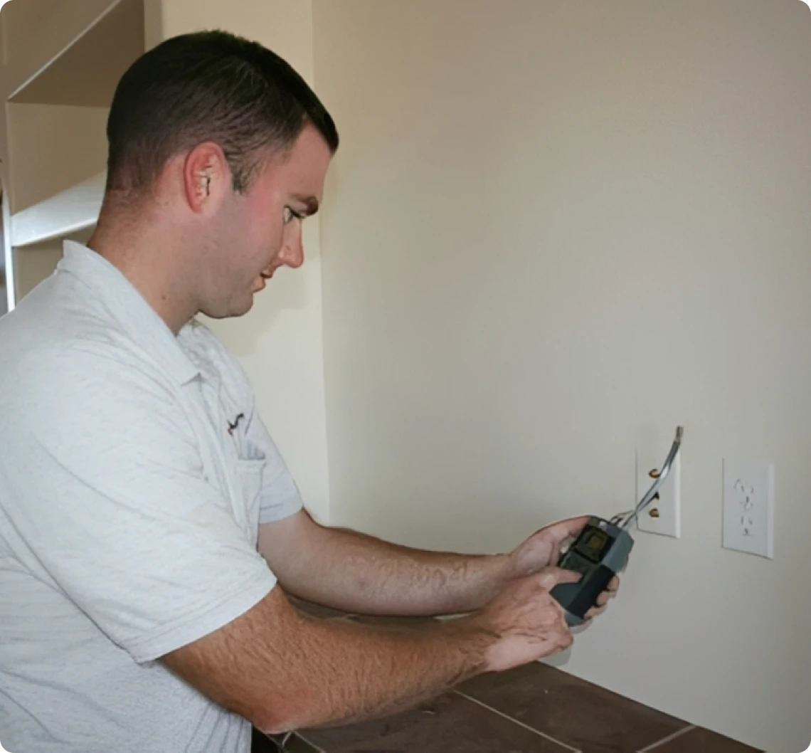 Person checking wall moisture levels.