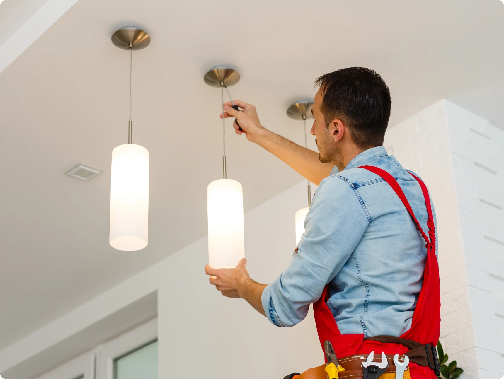 Electrician fixing ceiling light fixture
